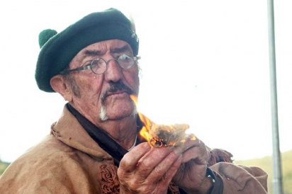A Craig sheepherder ignites hemp, traditionally used for making cooking fires